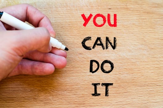 Human hand over wooden background and you can do it text concept