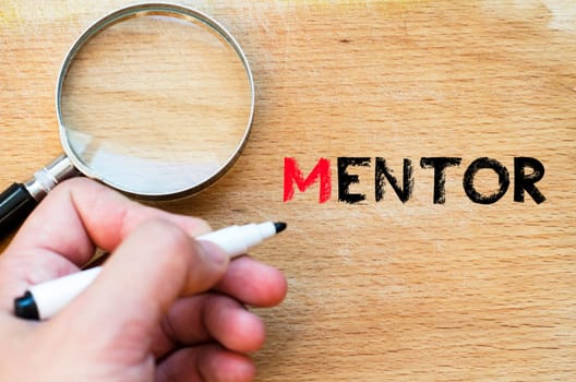 Human hand over wooden background and mentor text concept
