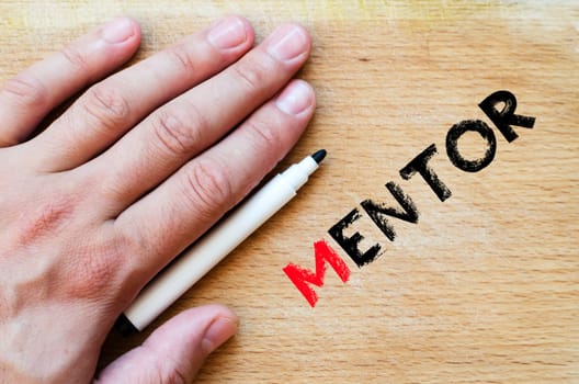 Human hand over wooden background and mentor text concept