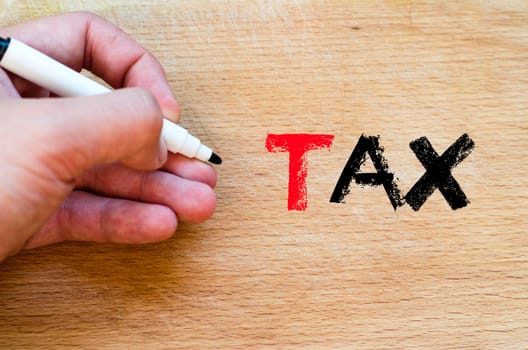 Human hand over wooden background and tax text concept