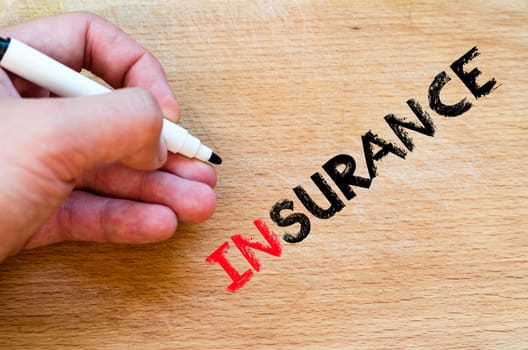 Human hand over wooden background and insurance text concept