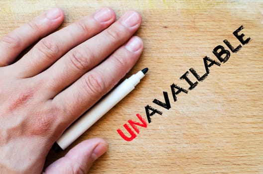Human hand over wooden background and unavailable text concept