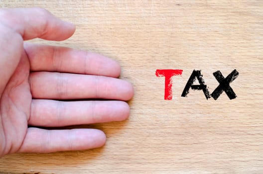 Human hand over wooden background and tax text concept