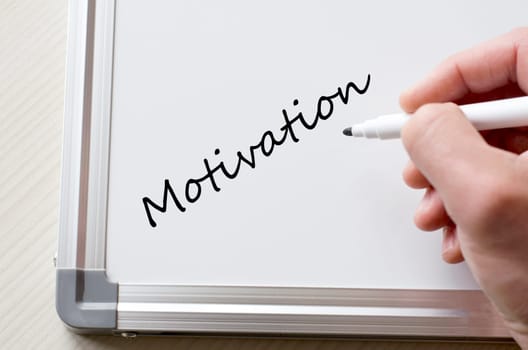 Human hand writing motivation on whiteboard