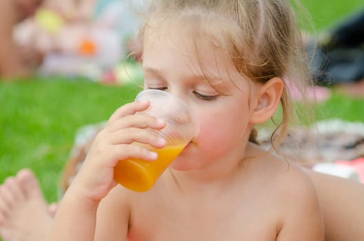 Girl drinking fruit juice from a plastic disposable cup