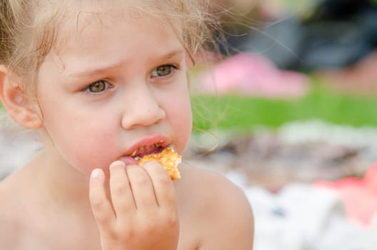 Girl eating cookies and drinking juice from a plastic disposable cup