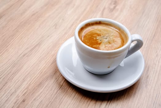 cup of coffee on wooden table from above