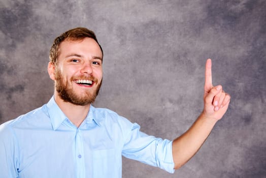 young bearded man is surprised and showing forefinger