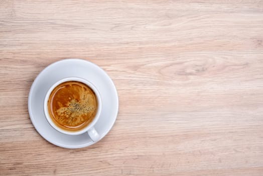 cup of coffee on wooden table from above