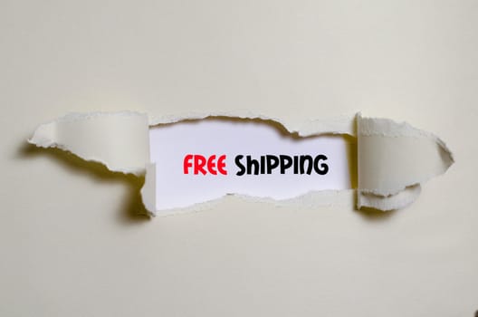 The word free shipping appearing behind torn paper