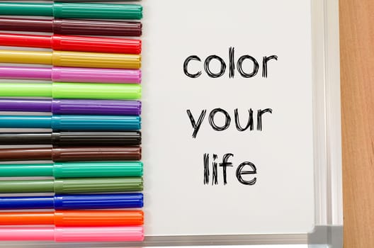 Felt-tip pen and whiteboard on a wooden background and color your life text concept