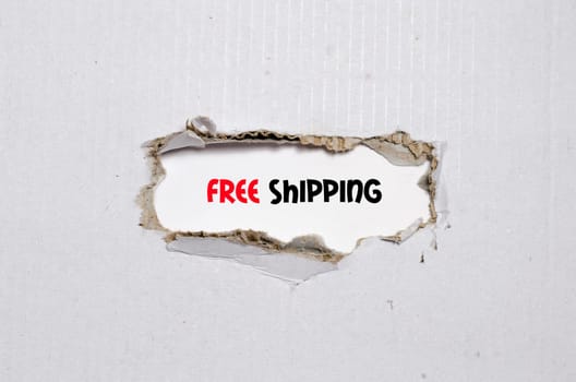 The word free shipping appearing behind torn paper