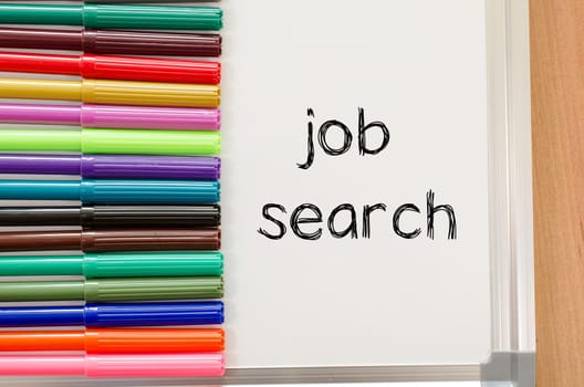 Felt-tip pen and whiteboard on a wooden background and job search text concept