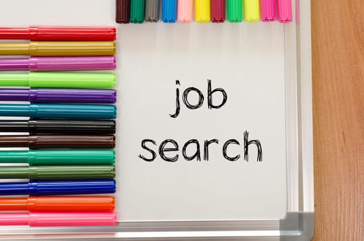 Felt-tip pen and whiteboard on a wooden background and job search text concept
