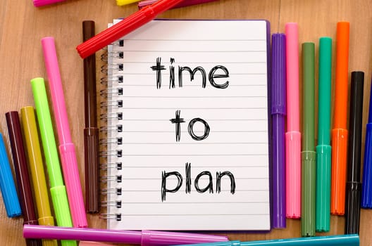 Felt-tip pen and notepad on a wooden background and time to plan text concept
