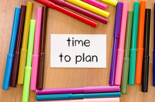 Felt-tip pen and note on a wooden background and time to plan text concept