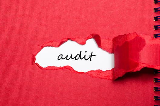 The word audit appearing behind torn paper