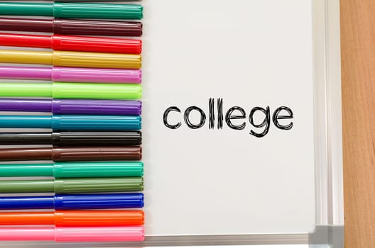 Felt-tip pen and whiteboard on a wooden background and college text concept