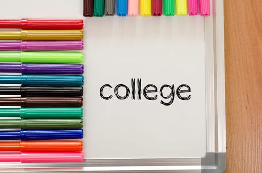 Felt-tip pen and whiteboard on a wooden background and college text concept