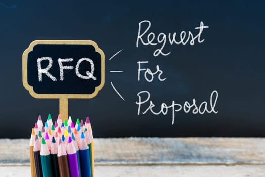 Business Acronym RFQ Request For Proposal written with chalk on wooden mini blackboard labels and chalkboard background.