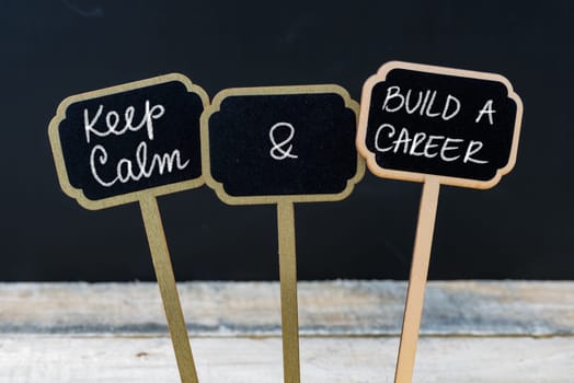 Keep Calm and Build A Career message written with chalk on mini blackboard labels, defocused chalkboard and wooden table in background. Fun and humor concept