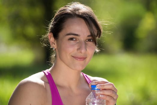 beautiful athletic girl drinking water after exercising