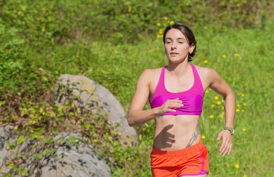 Beautiful  young athletic woman running in countryside