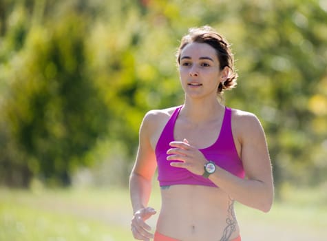 Beautiful  young athletic woman running in countryside
