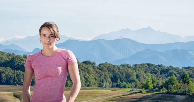portrait of young sporty woman , mountains in  background