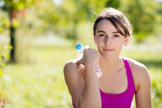 beautiful athletic girl drinking water after exercising