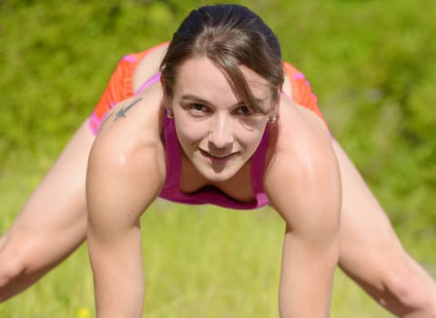 beautiful young fitness woman doing exercise in countryside