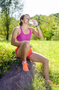 beautiful athletic girl drinking water after exercising