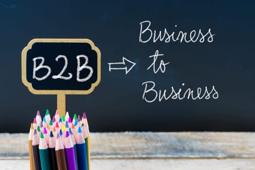 Business Acronym B2B Business To Business written with chalk on wooden mini blackboard labels and chalkboard background.