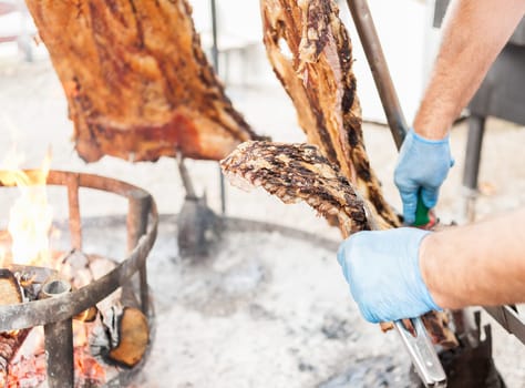Asado, traditional barbecue dish in Argentina, roasted meat of beef cooked on a vertical grills placed around fire