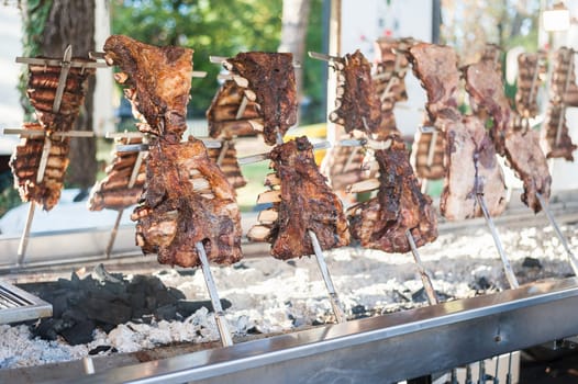 Asado, traditional barbecue dish in Argentina, roasted meat of beef cooked on a vertical grills placed around fire