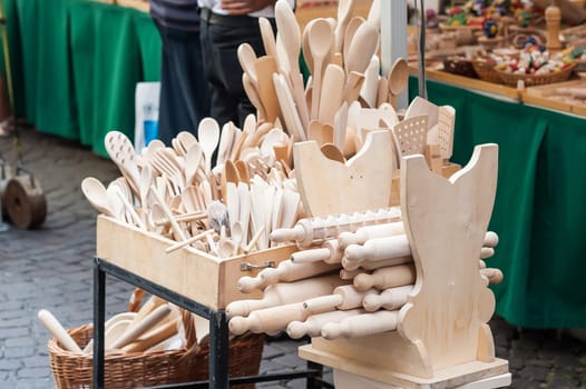 Handmade wooden, vintage kitchen utensils for sale at the market. Various wooden kitchen tools. Different wooden tableware.