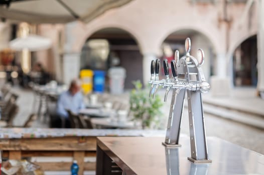 Draught beer taps and other beverages in a bar.