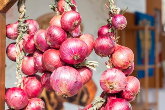 Red onion braids sold in Italy in the Farmer's Market.