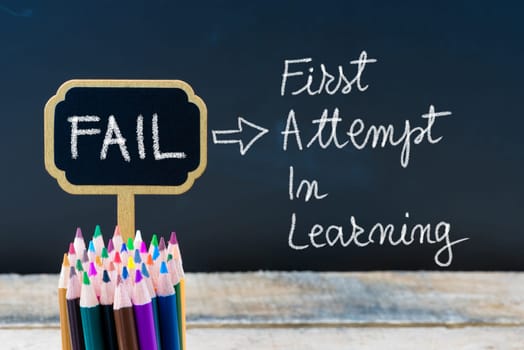 Business Acronym FAIL First Attempt In Learning written with chalk on wooden mini blackboard labels and chalkboard background.