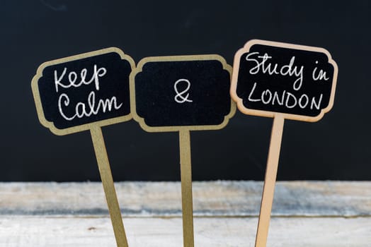 Keep Calm and Study In London message written with chalk on mini blackboard labels, defocused chalkboard and wooden table in background. Fun and humor concept