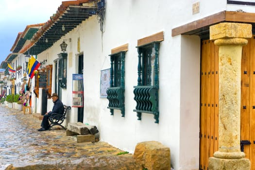 VILLA DE LEYVA, COLOMBIA - APRIL 27: Old man sitting on a bench in the colonial town of Villa de Leyva, Colombia on April 27, 2016