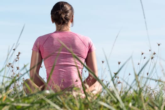 young sporty woman with a pink sportswear, back view
