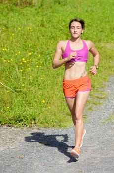 Beautiful  young athletic woman running in countryside