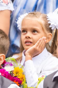 First grader on the line of the first of September thinking looking up