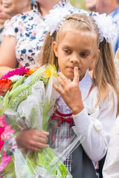 First grader on the line of the first of September in thought looking down