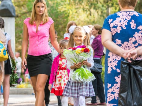 First grader goes to school with his mother and younger sister