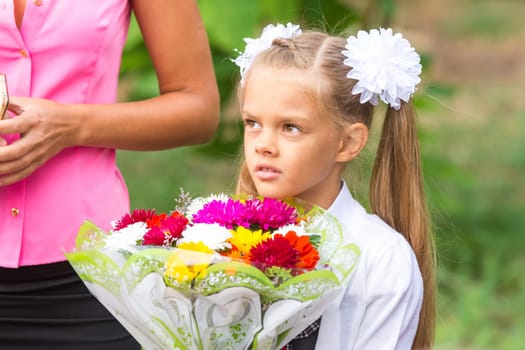 Portrait of a seven-year schoolgirl, standing next to my mother