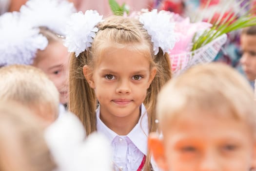 First grader close-up in a crowd of children on line the first of September