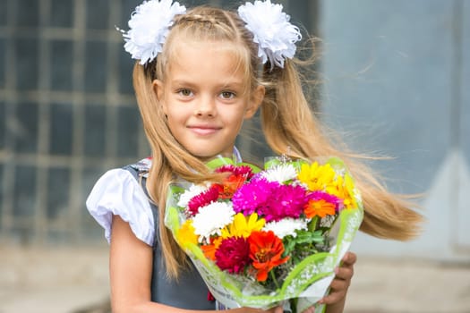 Up portrait of first-grader with a bouquet of flowers