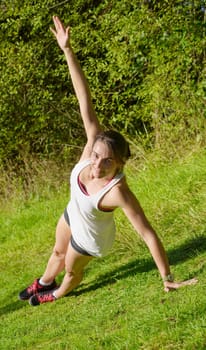 beautiful young fitness woman doing exercise in countryside